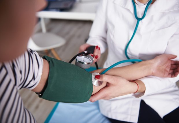Doctor taking patient's blood pressure